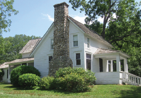 White house with a large stone chimney.