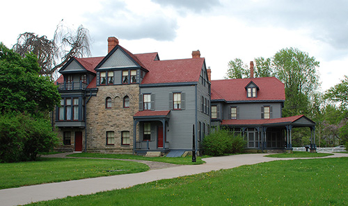 Outdoor view of Garfield's blue house with a red roof.