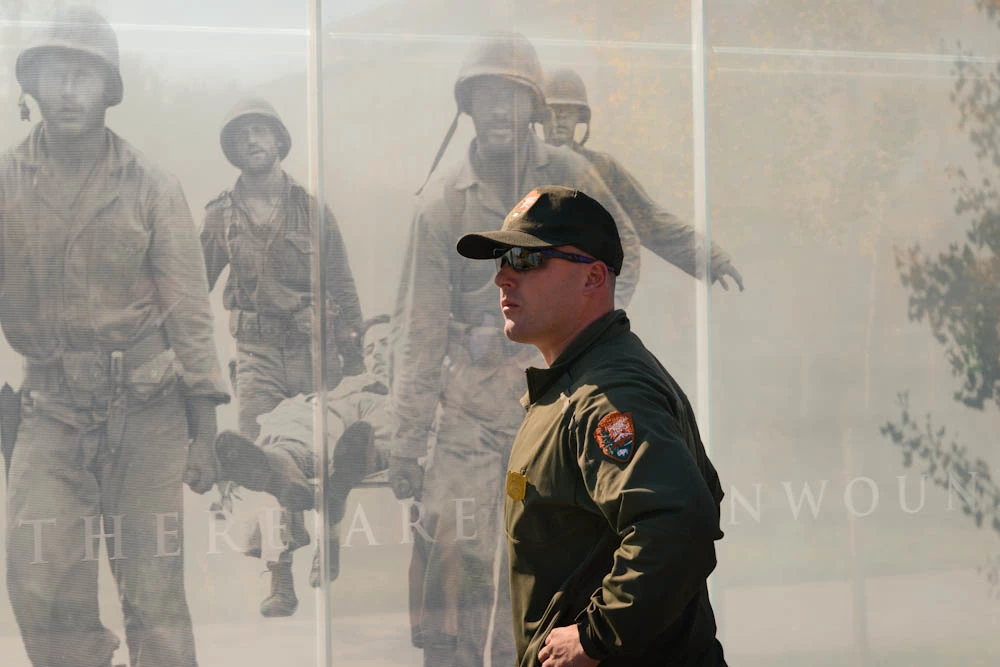 James Pierce at the American Veterans Disabled for Life Memorial NPS staff in front of photos of soldiers