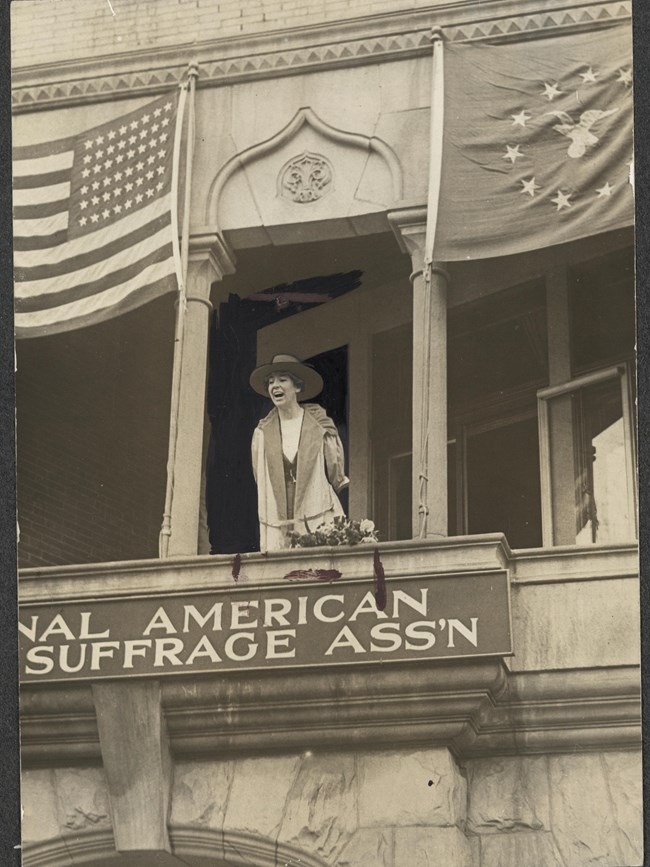 Altered photo of Jeannette Rankin on the balcony of NAWSA headquarters in Washington