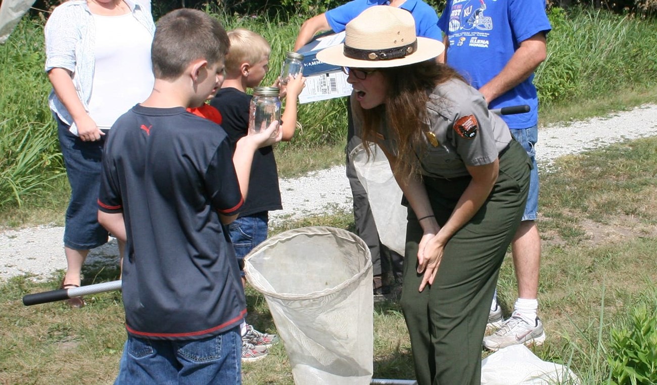 Jessica Bioblitz Park Ranger and child look at insect in jar