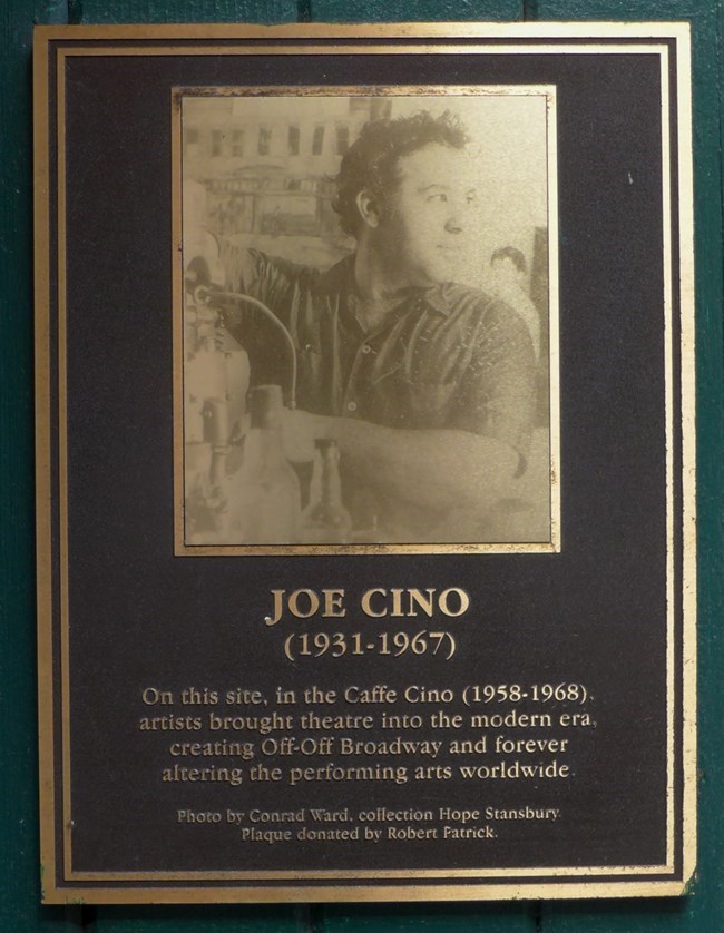 Plaque at 31 Cornelia in Manhattan where Caffe Cino once stood showing Joe Cino. A photo of a metal plaque with a image of a husky man at an espresso machine
