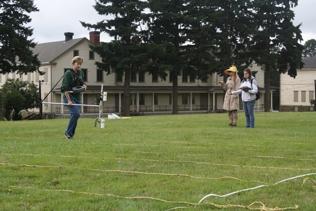 Archaeologist holds equipment for sub-surface survey