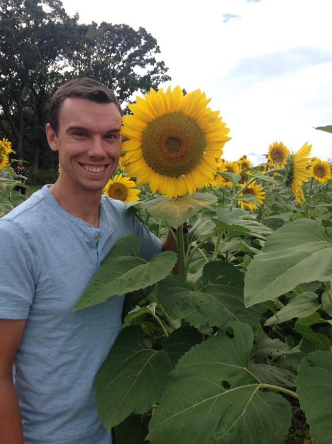 Photo of Dr. Poinsatte Dr. Poinsatte smiling with sunflowers.