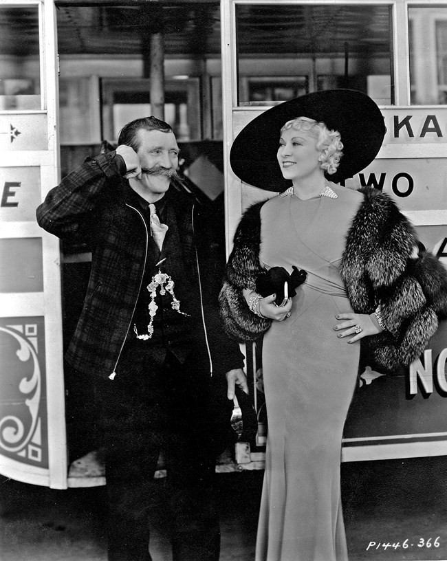 Martin Itjen smiling and standing next to Mae West