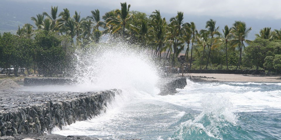 Waves crashing against a massive black sea wall