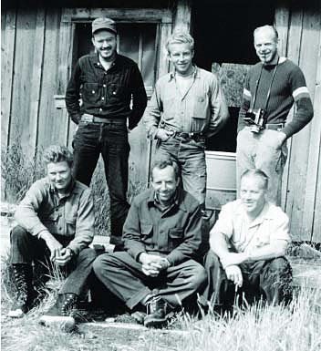 Katmai Project 1953-1954 A group of six white men pose in front of an old NPS park building for the Katmai Project.