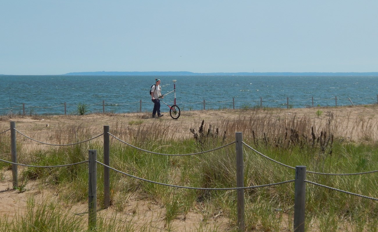 Katy ames uses a rover GPS on sand dunes along the coast