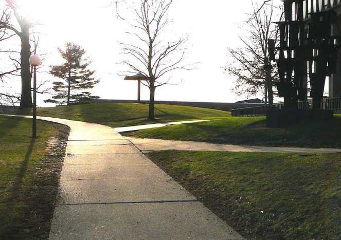 Green grass with sidewalks and a black, metal structure.