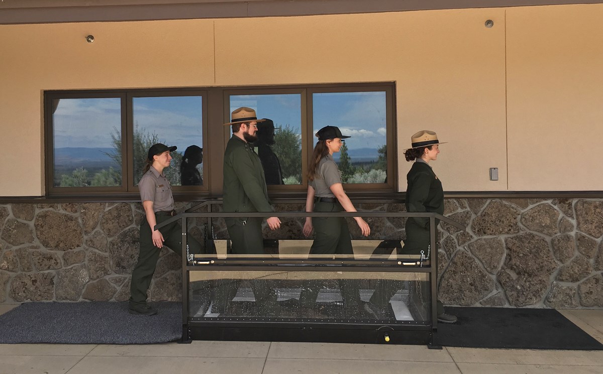 four rangers walking through shoe cleaning station