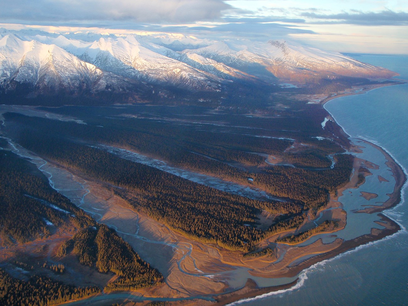 An aerial view of the Red River and mountains near the Lake Clark coast