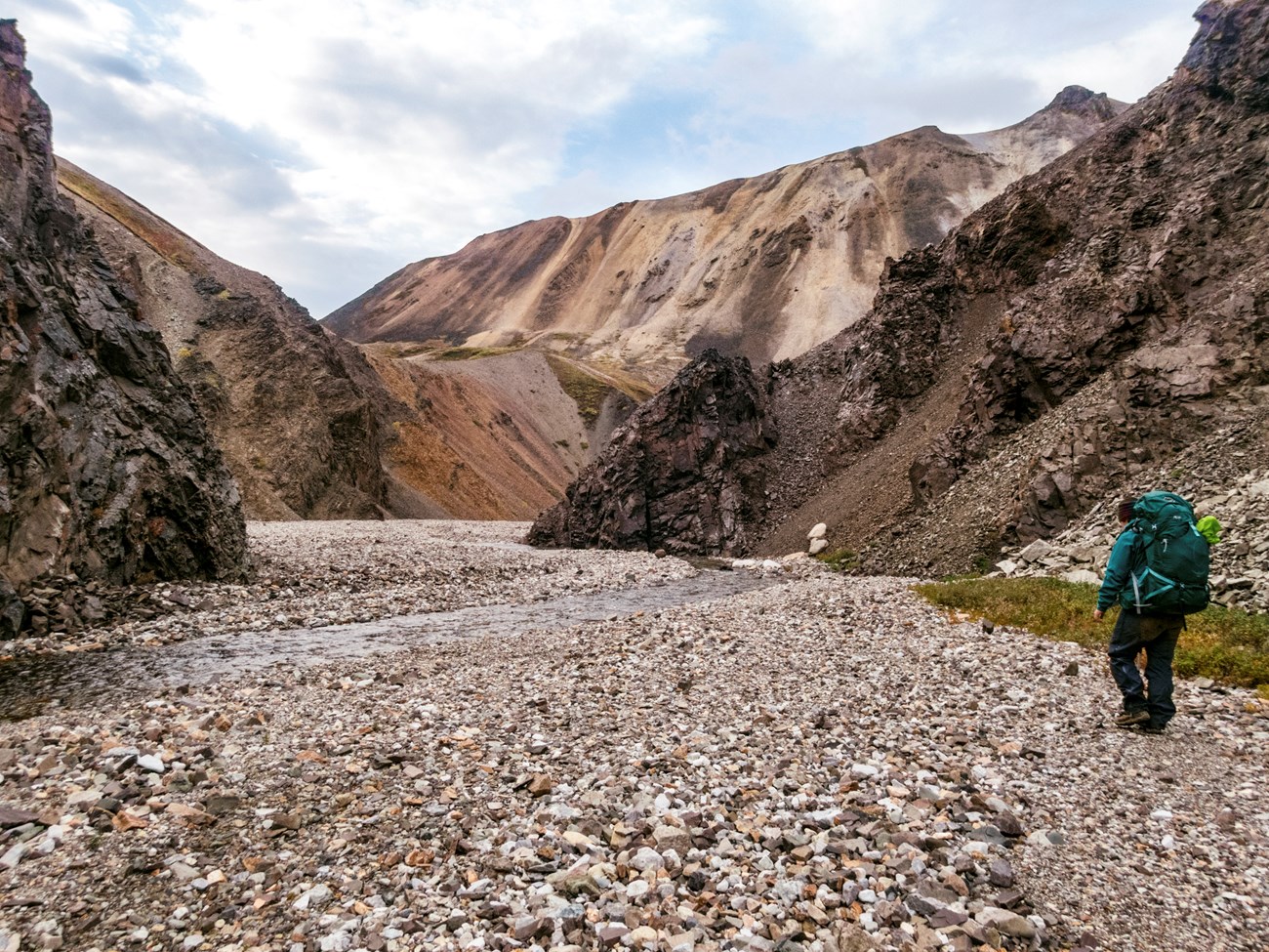 Image of backpacker in a rocky canyon by river.