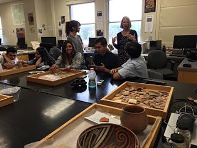 Students work on archeological artifacts in a lab setting Students work on archeological artifacts in a lab