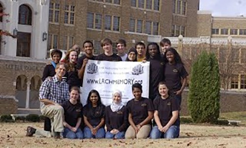 A group of people holding a Memory Project banner outside Little Rock Central High