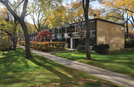 Lafayette Park, Detroit, Michigan Townhouse units with large windows surrounded by orange and green trees.