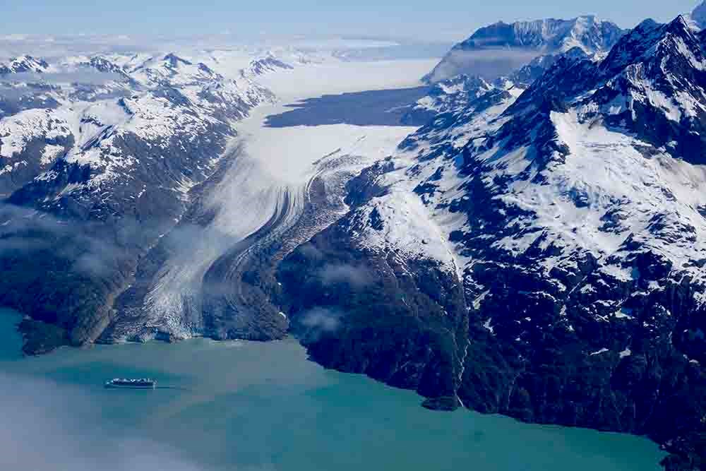 An aerial view of a cruise ship and tidewater glacier.