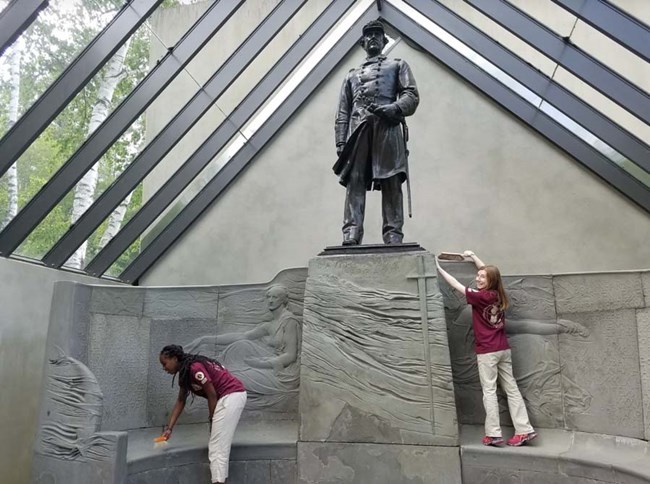 Leah and Abigail cleaning Farragut statue two interns cleaning a statue of Farragut at Saint-Gaudens. NPS photo