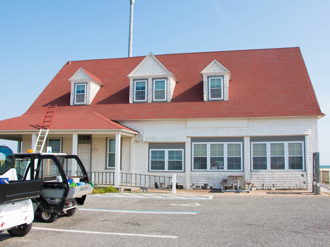 A red roofed building with a small parking lot. A red roofed building with a small parking lot.
