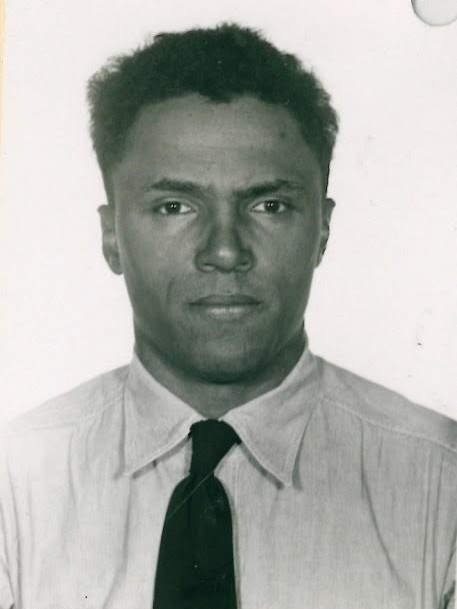 A man in a collared shirt with a dark tie