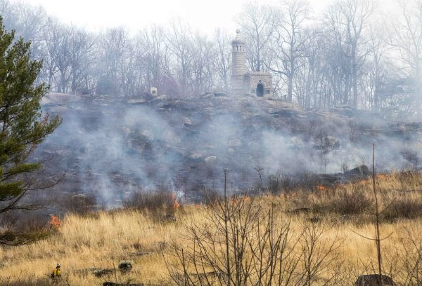 Fire burns a dry hillside.