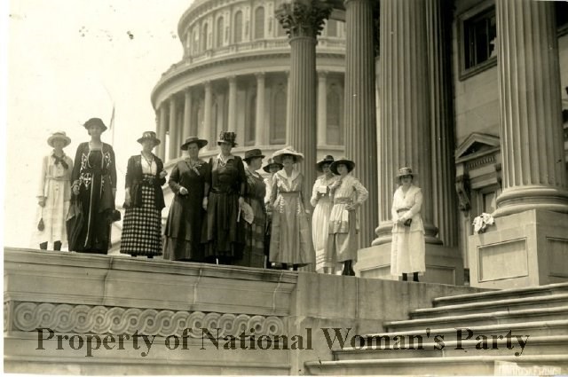 Ten women suffragists with Capitol dome in background