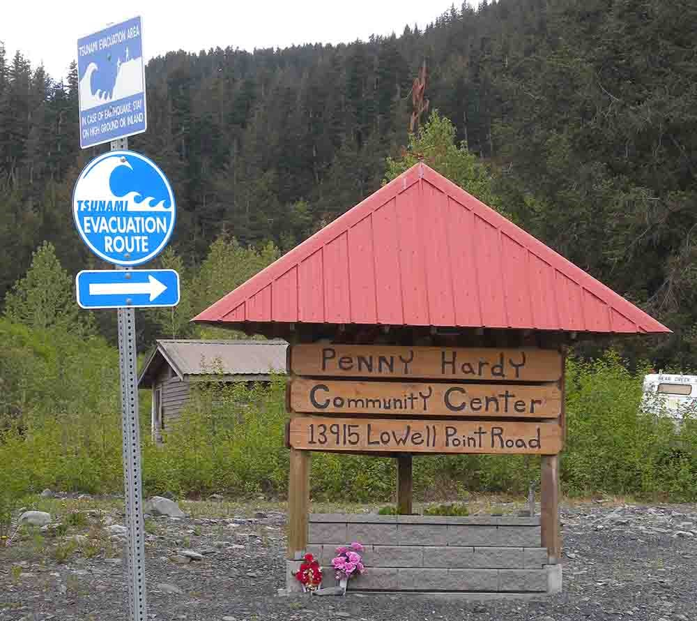 A sign pointing toward a community center and tsunami evacuation route near Kenai Fjords National Park.