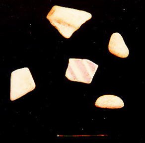 five diamond-shaped pieces of worn ceramic or glass. five diamond-shaped pieces of worn ceramic or glass.