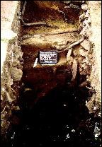Photograph of pit area of the Robinson's ice house/trash pit during excavations. A small sign sits in the pit.