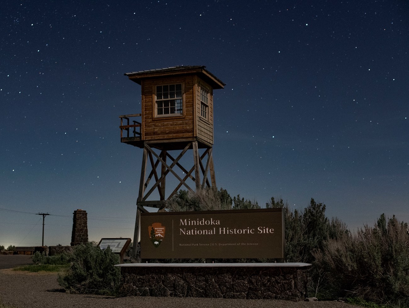 Guard tower and sign for Minidoka National Historic Site at night