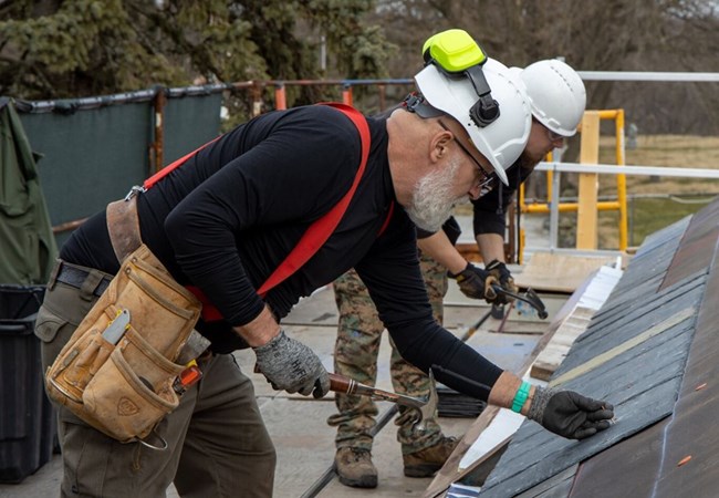 Mike Owens hammering roofing material