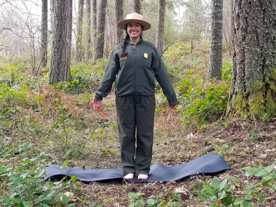 Mount Rainier Yoga: Mountain Pose A ranger stands with a yoga pose with arms down.