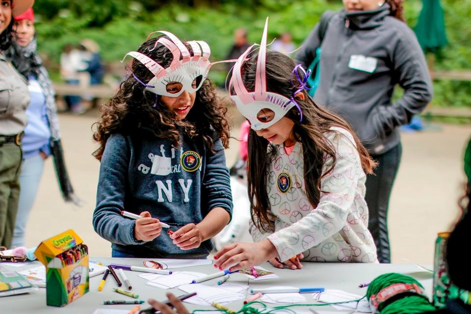 Two kids wearing masks doing an arts and crafts project