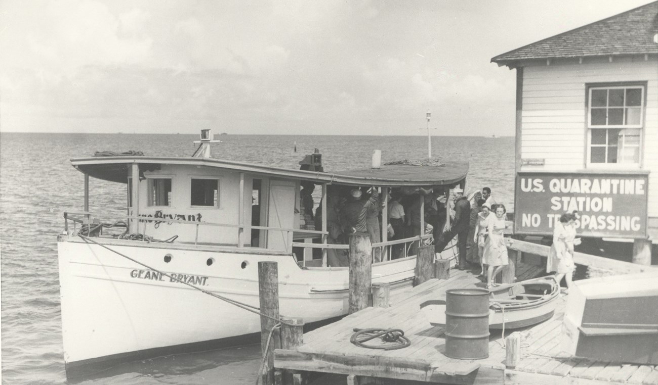 Passengers disembark from a small vessel at the US Quarantine Station.