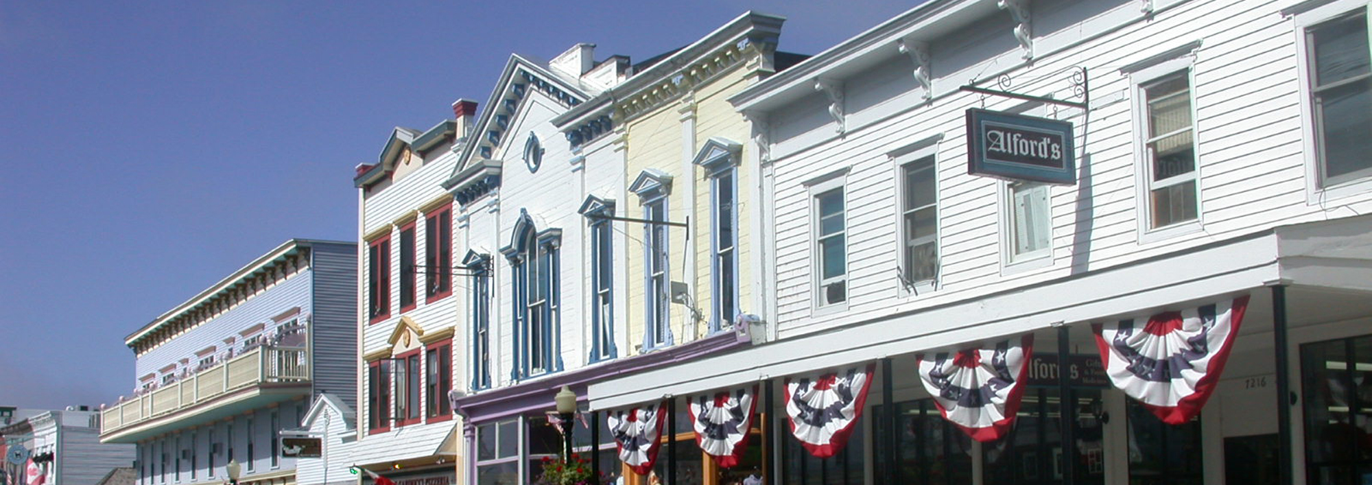 A row of blue, and yellow store fronts with red and blue windows.