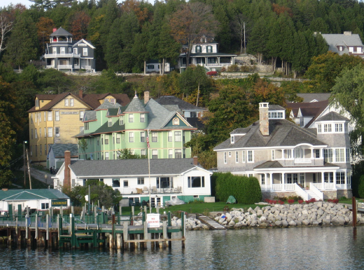 View of Mackinac Island Houses on a hill by a lake.