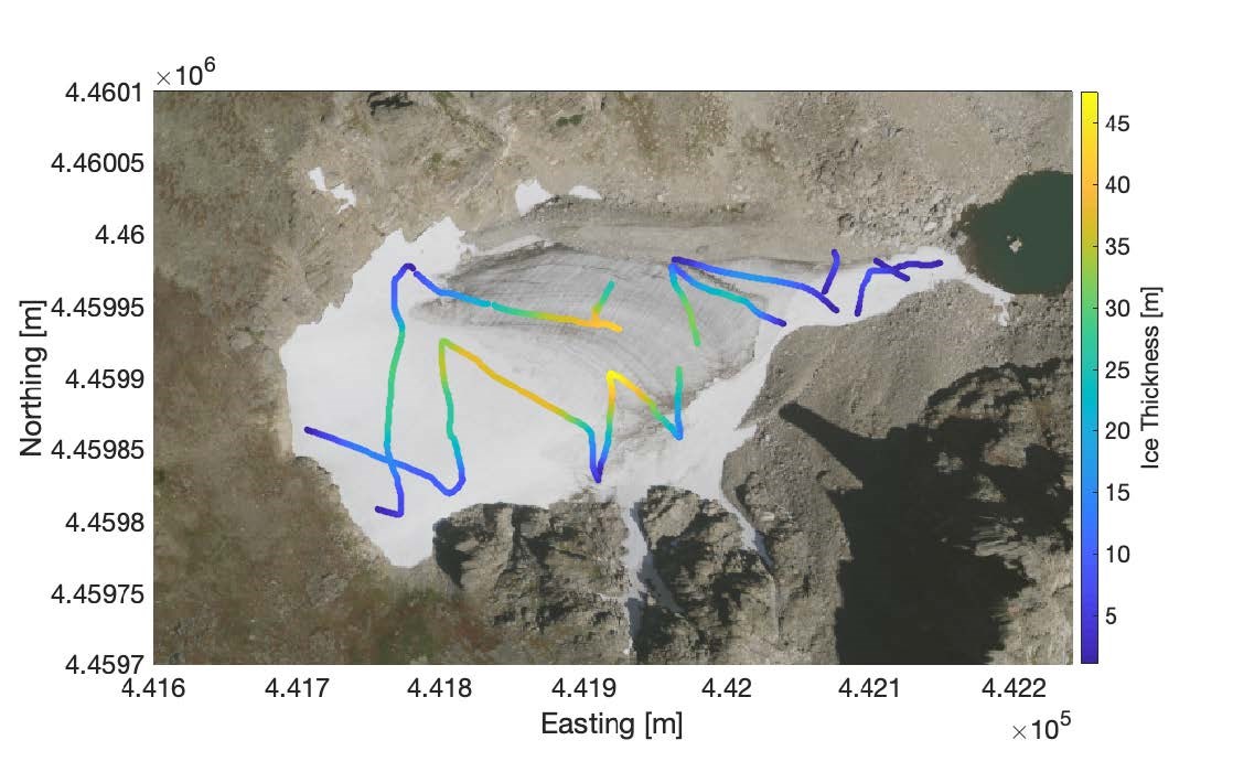 An aerial view of Andrews Glacier. Colorful lines across the surface represent different thicknesses of ice and snow.