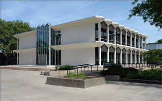 McGregor Memorial Conference Center Large, white stone building with black windows and a pond in front.