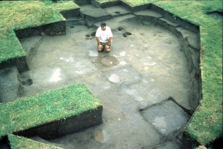 A man sitting in the remnants of an ancient house.