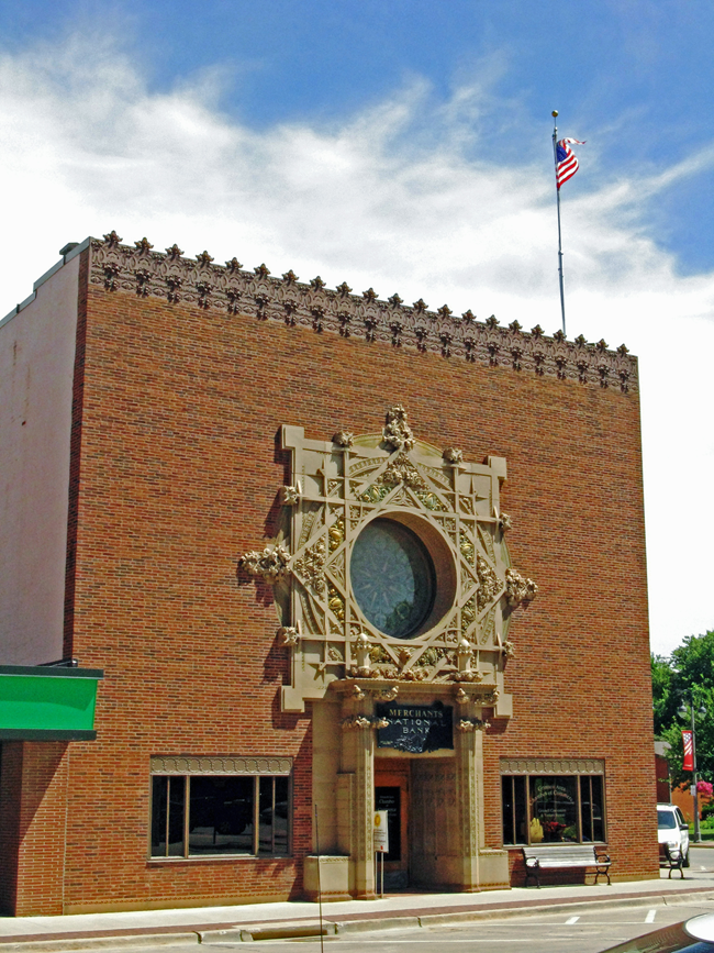 Merchant's National Bank Brick building with a circle window and architectural detail.