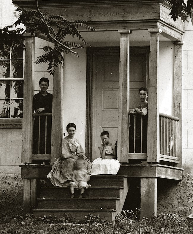 Cropped and enlarged photograph of the Miller farm taken in late September or early October of 1862 showing women and children thought to be members of the Miller Family.  Their farm was the site of the battle in the famous Cornfield at Antietam. Library