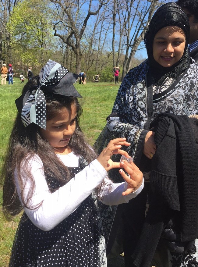 Mother and daughter examine a honeybee