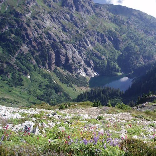 A subalpine lake tucked into a narrow rocky valley.