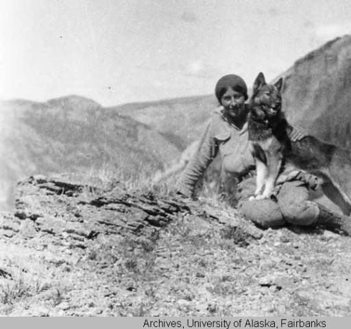 Murie and Dog a woman sitting on a mountain top with a dog