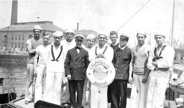 Group of sailors posed with a life saver in the center of the group.