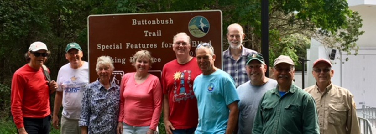 NPLD Volunteer Group A group of people stand in front of a sign that reads, "Buttonbush Trail."