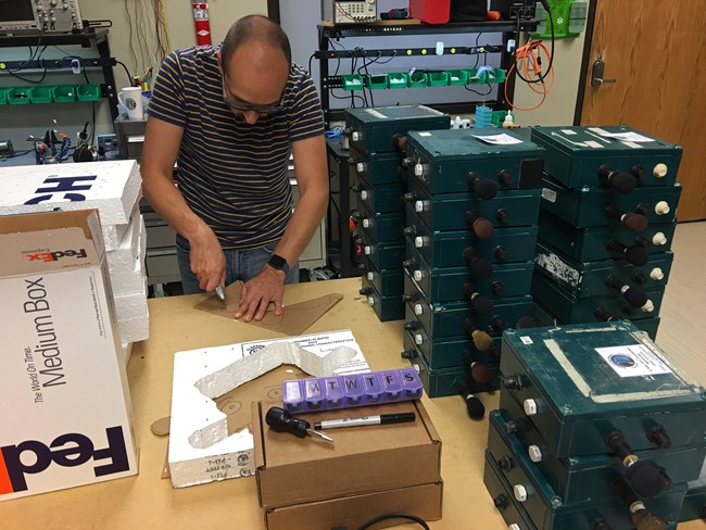 A National Park Service acoustic specialist prepares audio recording equipment and packaging for national parks participating in the Eclipse Soundscapes project.