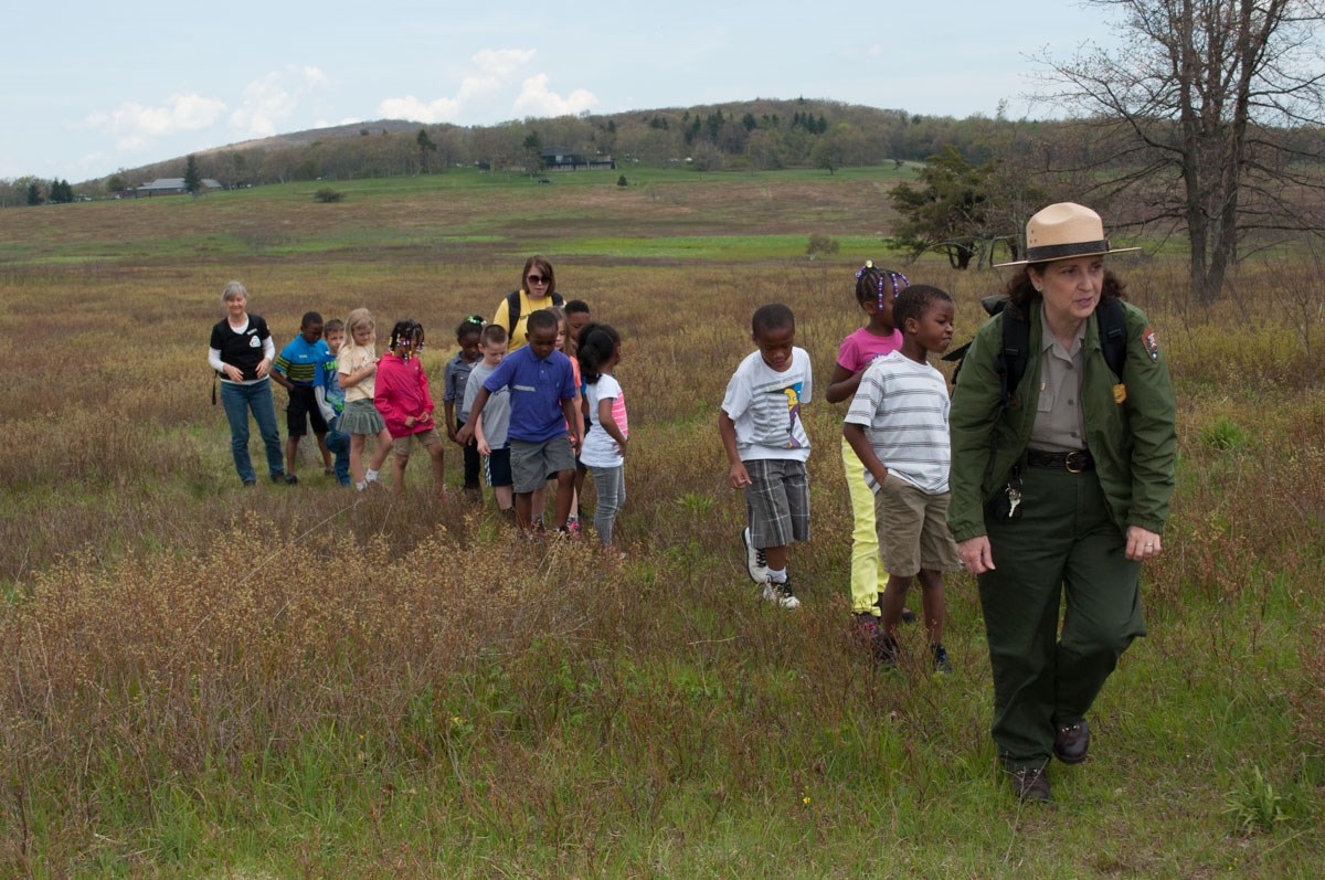 A group of students out on a hike with their chaperones and a park ranger. A group of students out on a hike with their chaperones and a park ranger.