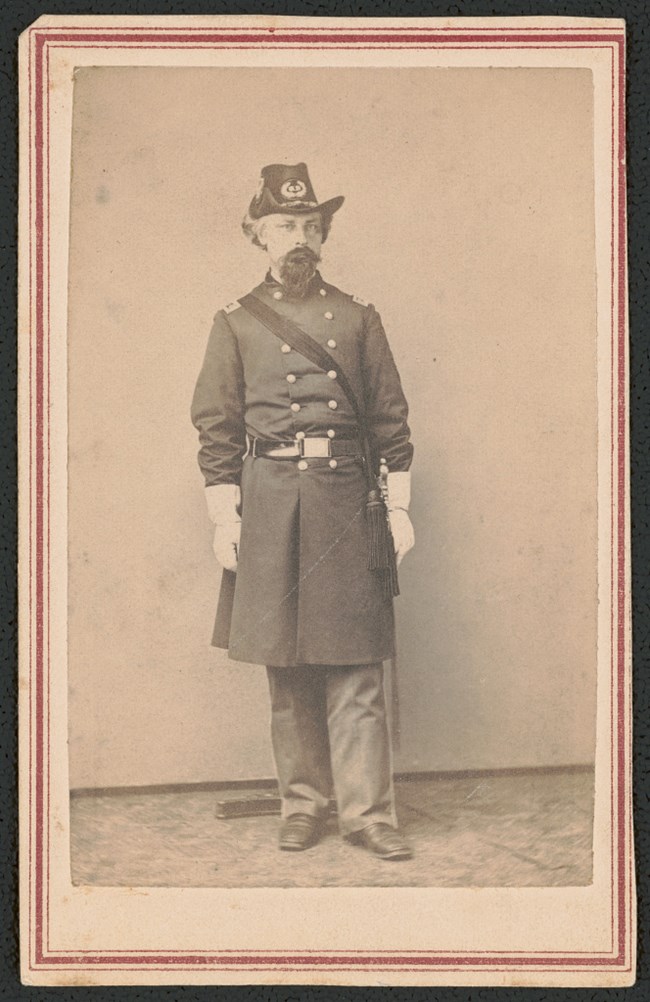 Civil War officer, with white gloves, long blue coat and a beard