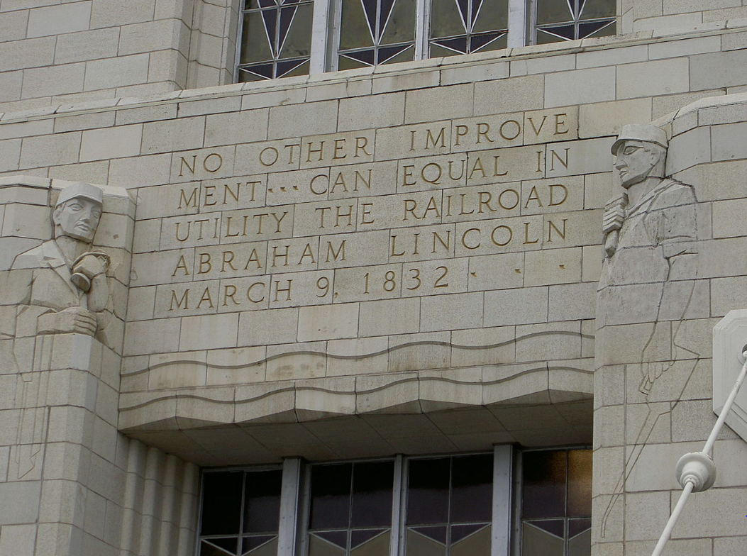 lt= Stone carvings of words and two men into the side of Omaha Union Station.
