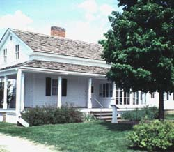 Owen Lovejoy House Small, white house with a front porch and tree.